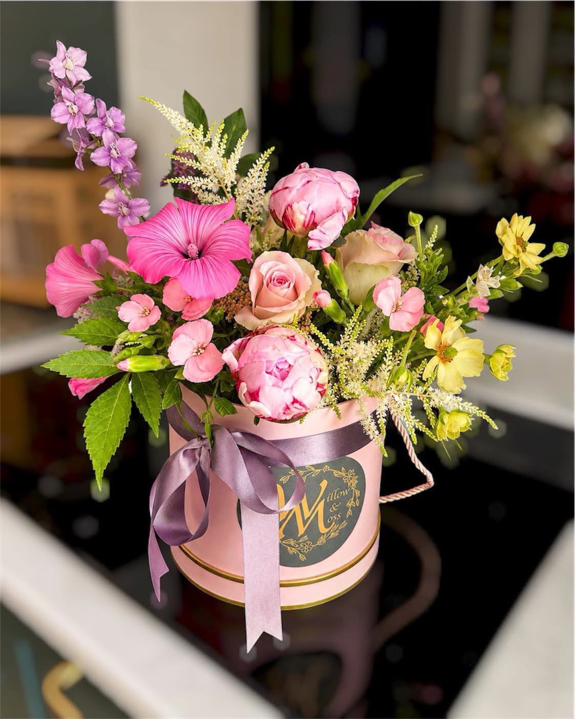 Flowers arranged in a hat box by Willow and Moss